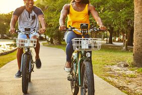 couple riding electric bicycles trail helmets laughing